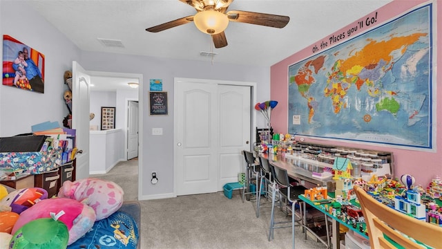 playroom with ceiling fan and light colored carpet