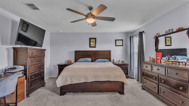 carpeted bedroom featuring ceiling fan and a textured ceiling