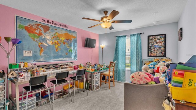 rec room featuring light carpet, a textured ceiling, and ceiling fan