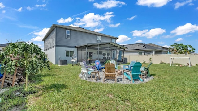 back of property with a lawn, a sunroom, an outdoor fire pit, and a patio area