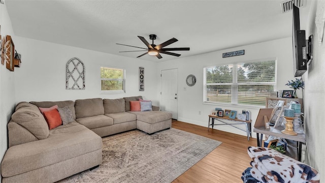 living room featuring a wealth of natural light, hardwood / wood-style floors, and ceiling fan