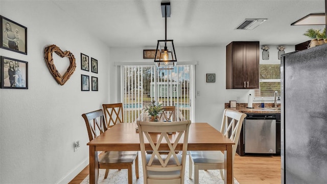 dining space featuring sink and light wood-type flooring