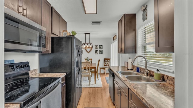 kitchen with light hardwood / wood-style flooring, sink, dark brown cabinetry, pendant lighting, and appliances with stainless steel finishes