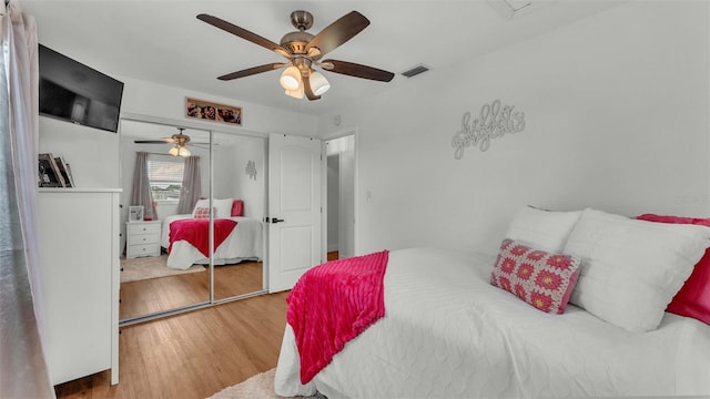 bedroom with a closet, hardwood / wood-style floors, and ceiling fan