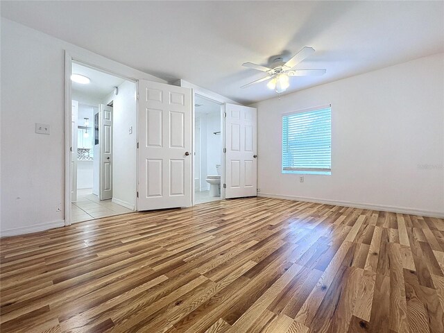 interior space with light hardwood / wood-style flooring, ceiling fan, and connected bathroom