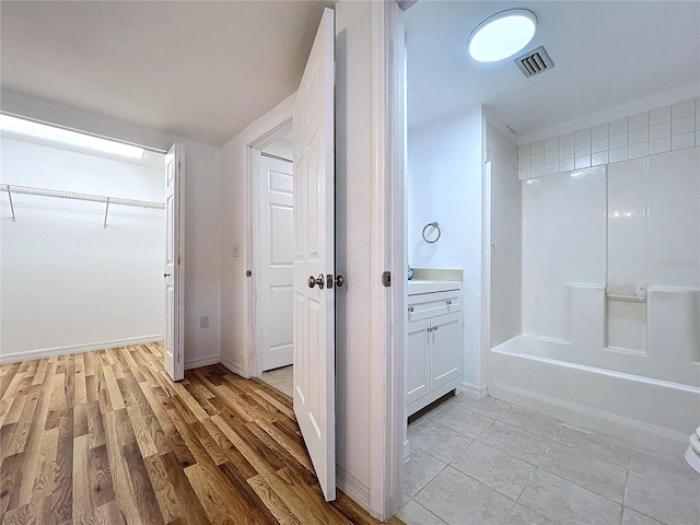 bathroom with hardwood / wood-style floors, shower / bath combination, and vanity