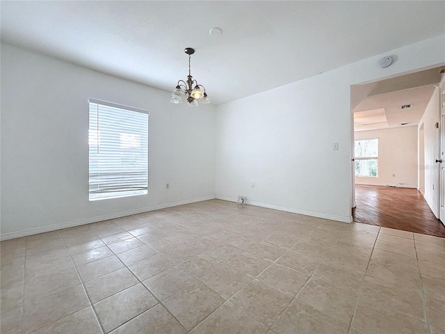 unfurnished room featuring light hardwood / wood-style floors and an inviting chandelier