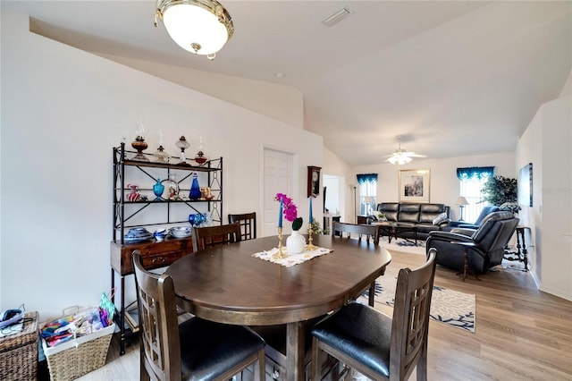 dining room with lofted ceiling, ceiling fan, and light wood-type flooring