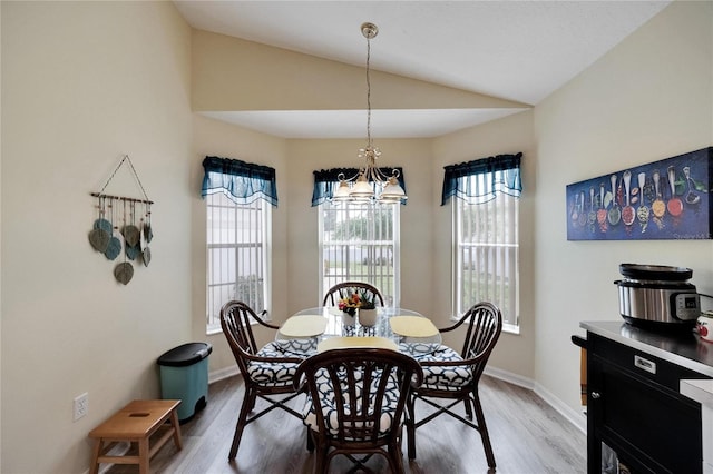 dining room with lofted ceiling and light wood-type flooring