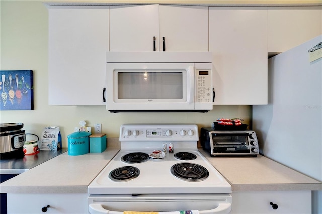 kitchen featuring white cabinetry and white appliances