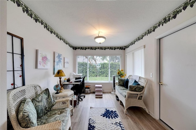 sitting room with a textured ceiling and light hardwood / wood-style floors