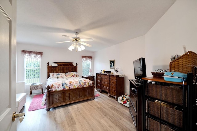 bedroom featuring multiple windows, light hardwood / wood-style flooring, and ceiling fan