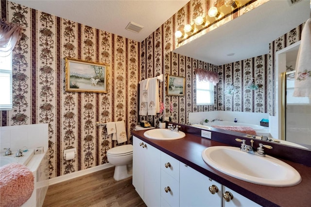 bathroom with vanity, hardwood / wood-style floors, a bathtub, and toilet