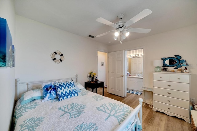 bedroom featuring sink, ensuite bath, ceiling fan, and light wood-type flooring