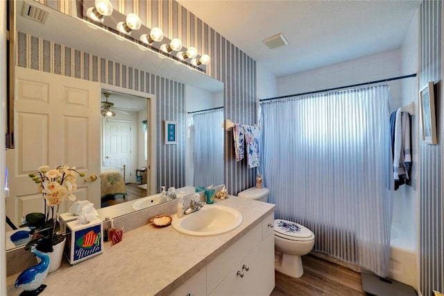 full bathroom featuring toilet, vanity, shower / bath combo with shower curtain, hardwood / wood-style flooring, and ceiling fan