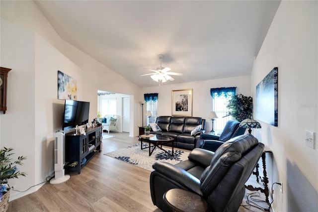 living room featuring ceiling fan, a wealth of natural light, vaulted ceiling, and light wood-type flooring