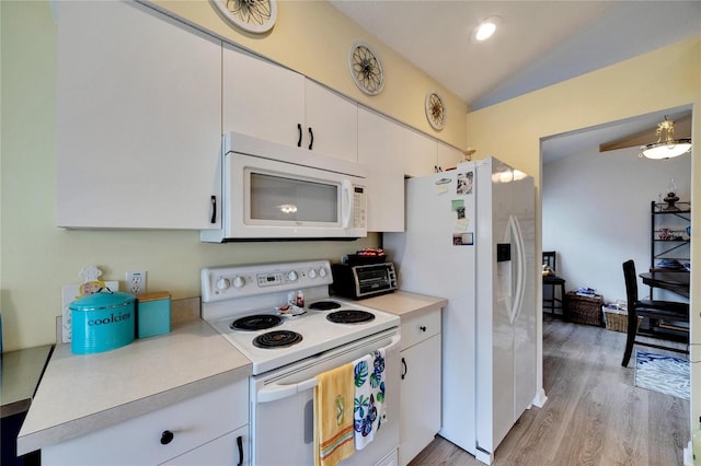 kitchen with white appliances, white cabinetry, light hardwood / wood-style floors, decorative light fixtures, and vaulted ceiling