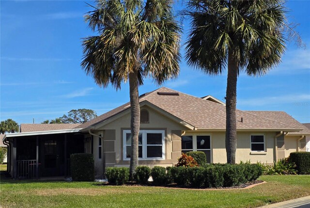 view of front facade with a sunroom and a front yard