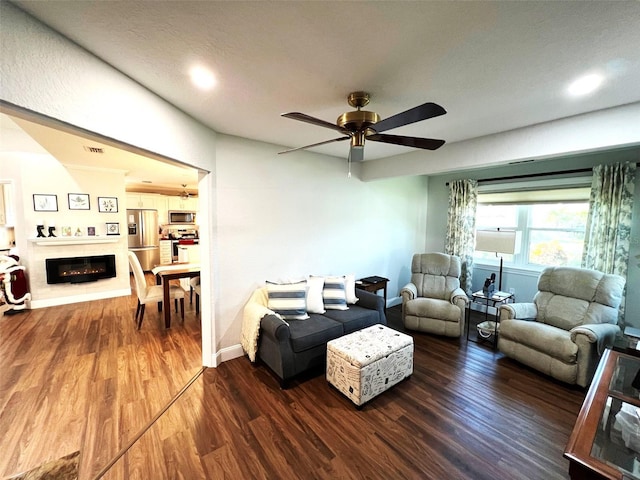 living room featuring ceiling fan, dark hardwood / wood-style flooring, and a textured ceiling