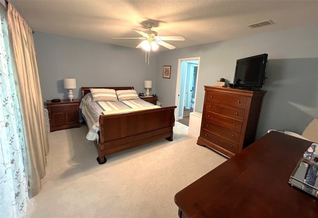 carpeted bedroom featuring ceiling fan and a textured ceiling