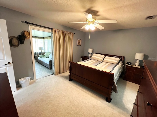 carpeted bedroom featuring a textured ceiling and ceiling fan