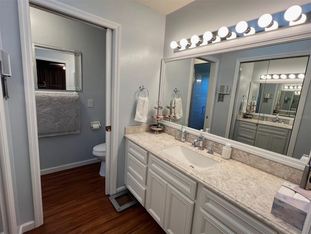 bathroom with vanity, wood-type flooring, a shower with shower door, and toilet