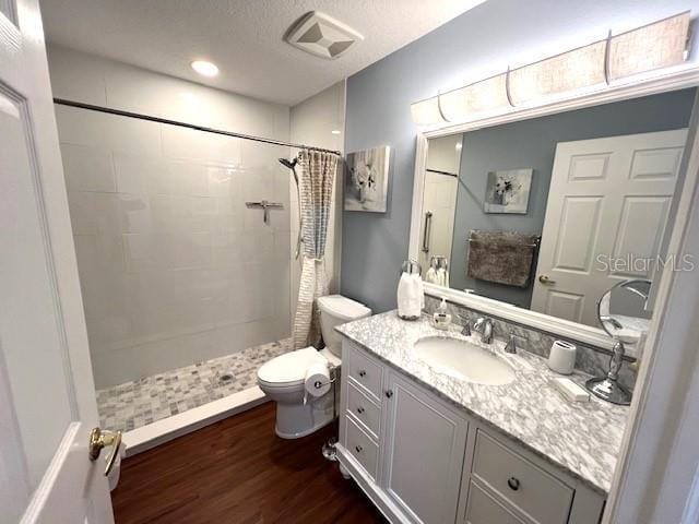 bathroom with a shower with curtain, vanity, hardwood / wood-style flooring, and toilet