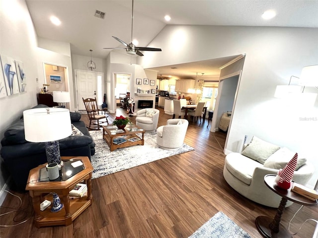 living room with hardwood / wood-style floors, ceiling fan, and high vaulted ceiling