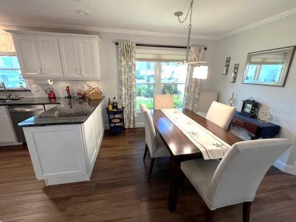 dining room with crown molding, sink, and dark hardwood / wood-style floors