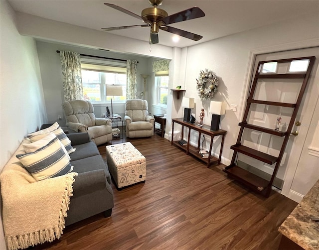 living room featuring ceiling fan and dark wood-type flooring