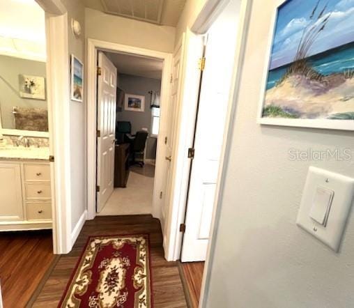 corridor featuring sink and dark wood-type flooring