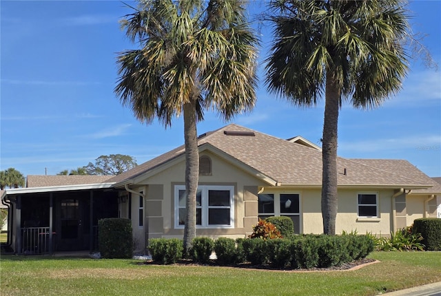 view of front facade featuring a sunroom and a front lawn