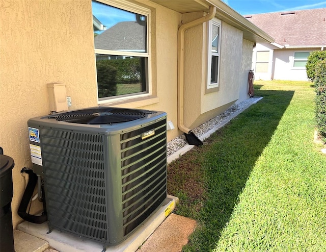 view of side of property featuring cooling unit and a yard