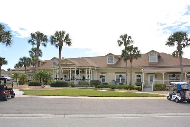 view of front of property featuring a front yard, a porch, and cooling unit