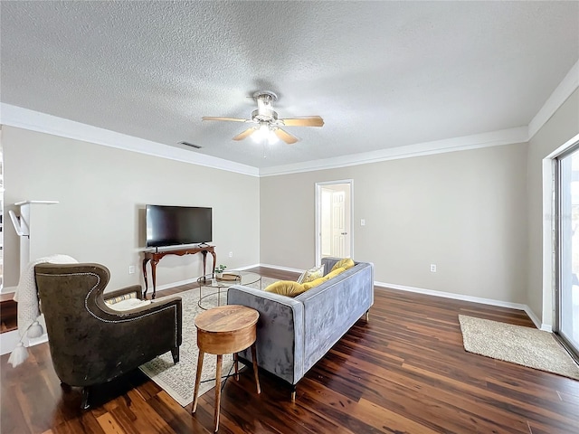 living room with ceiling fan, a textured ceiling, dark hardwood / wood-style flooring, and crown molding