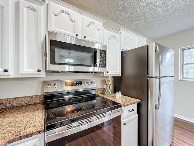 kitchen featuring white cabinetry, hardwood / wood-style flooring, light stone countertops, appliances with stainless steel finishes, and a textured ceiling