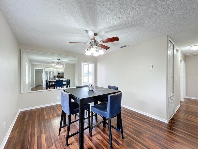 dining area featuring ceiling fan, a textured ceiling, and dark hardwood / wood-style floors