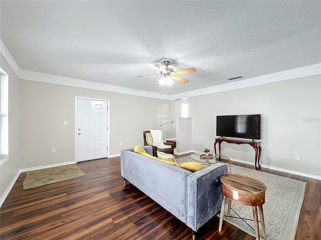 living room with a textured ceiling, dark wood-type flooring, crown molding, and ceiling fan