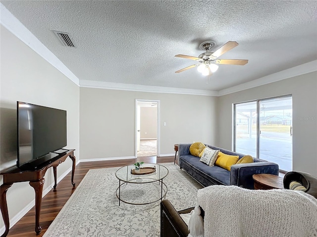 living room featuring a textured ceiling, ceiling fan, ornamental molding, and dark hardwood / wood-style floors