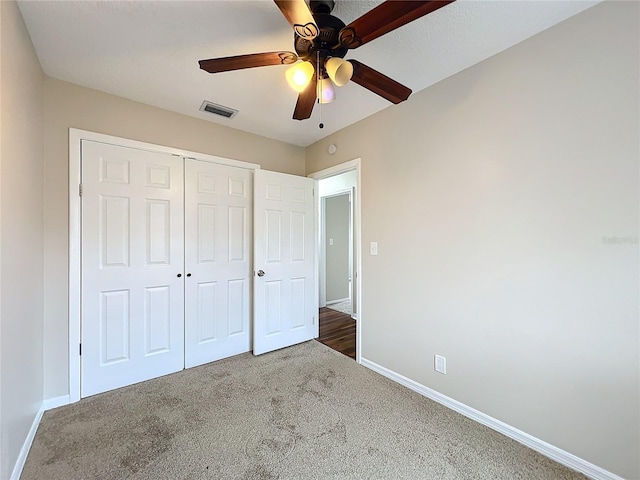 unfurnished bedroom with ceiling fan, carpet, and a closet