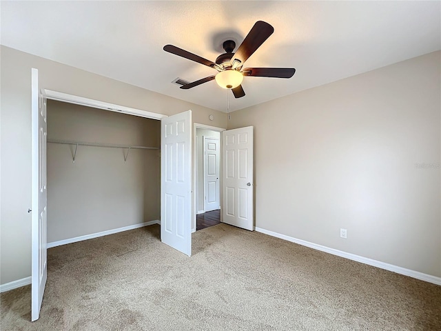 unfurnished bedroom with ceiling fan, a closet, and carpet flooring