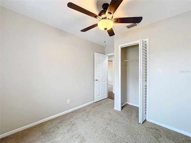 unfurnished bedroom with ceiling fan, a closet, and light colored carpet