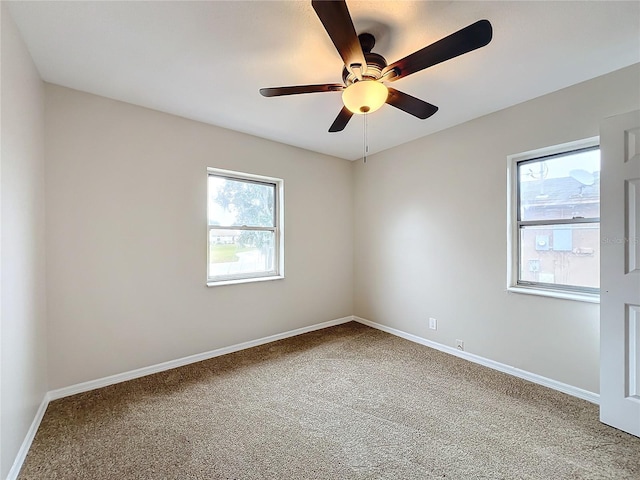 carpeted spare room featuring ceiling fan