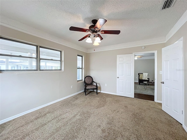 interior space with a textured ceiling, ceiling fan, carpet flooring, and ornamental molding