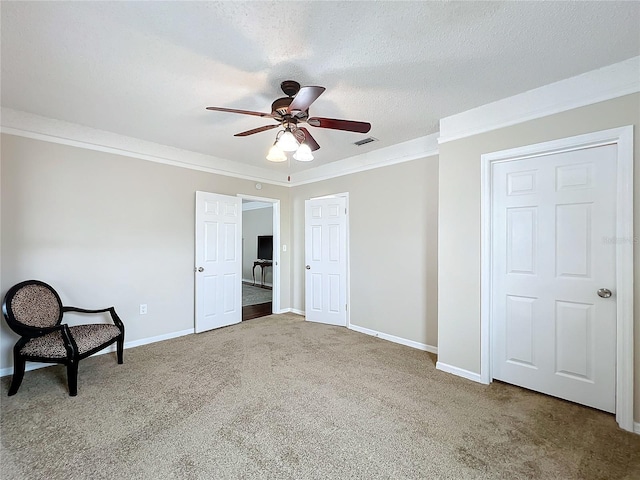 interior space with ceiling fan, crown molding, and carpet flooring