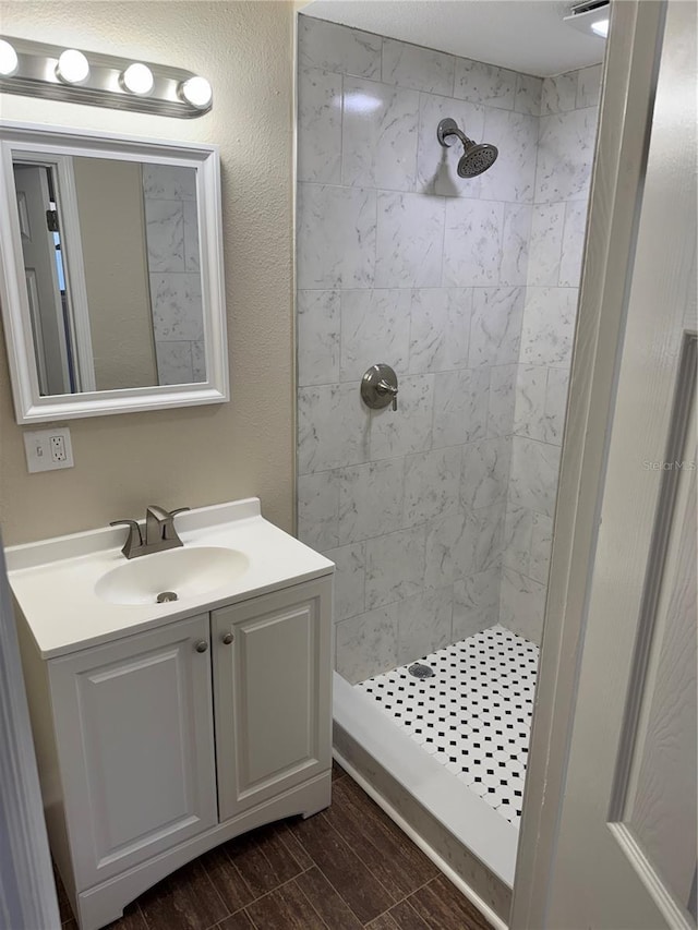 bathroom with vanity and a tile shower