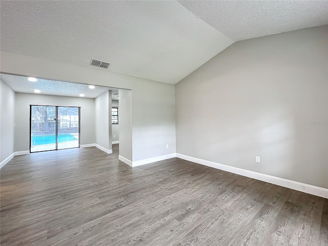 unfurnished room with wood-type flooring, lofted ceiling, and a textured ceiling