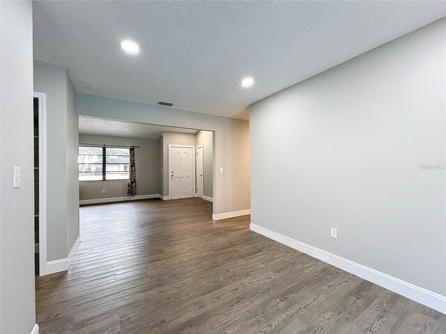 spare room featuring wood-type flooring and a textured ceiling