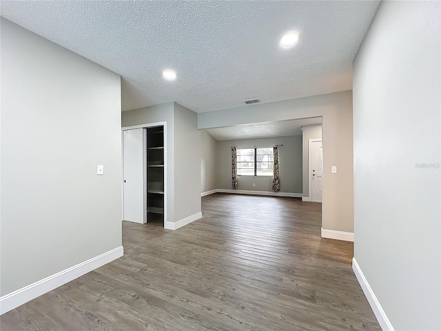 spare room featuring hardwood / wood-style floors and a textured ceiling