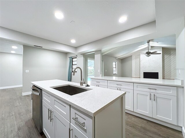 kitchen with white cabinets, a kitchen island with sink, dark wood-type flooring, and sink